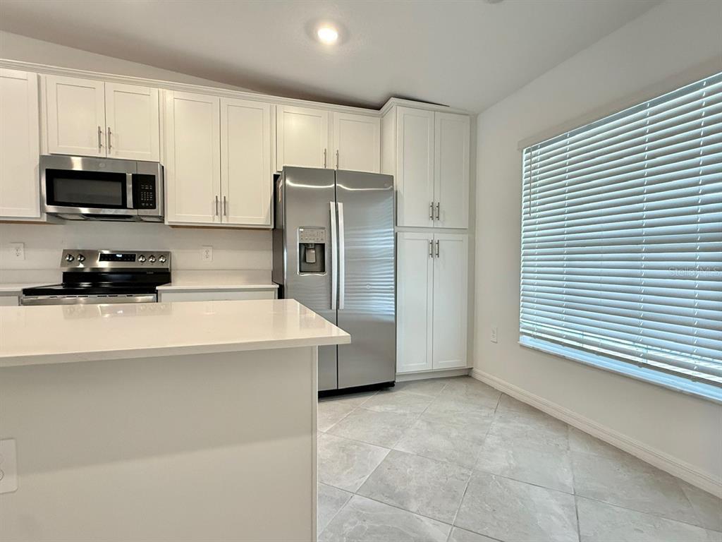 14261 Heritage Landing Boulevard, Unit 1621 Punta Gorda, FL 33955 - Photo 11 of 55 a kitchen with stainless steel appliances a refrigerator a stove a microwave and cabinets