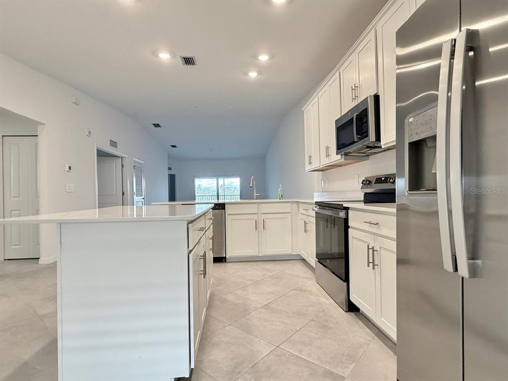 14261 Heritage Landing Boulevard, Unit 1621 Punta Gorda, FL 33955 - Photo 13 of 55 a kitchen with cabinets and white appliances