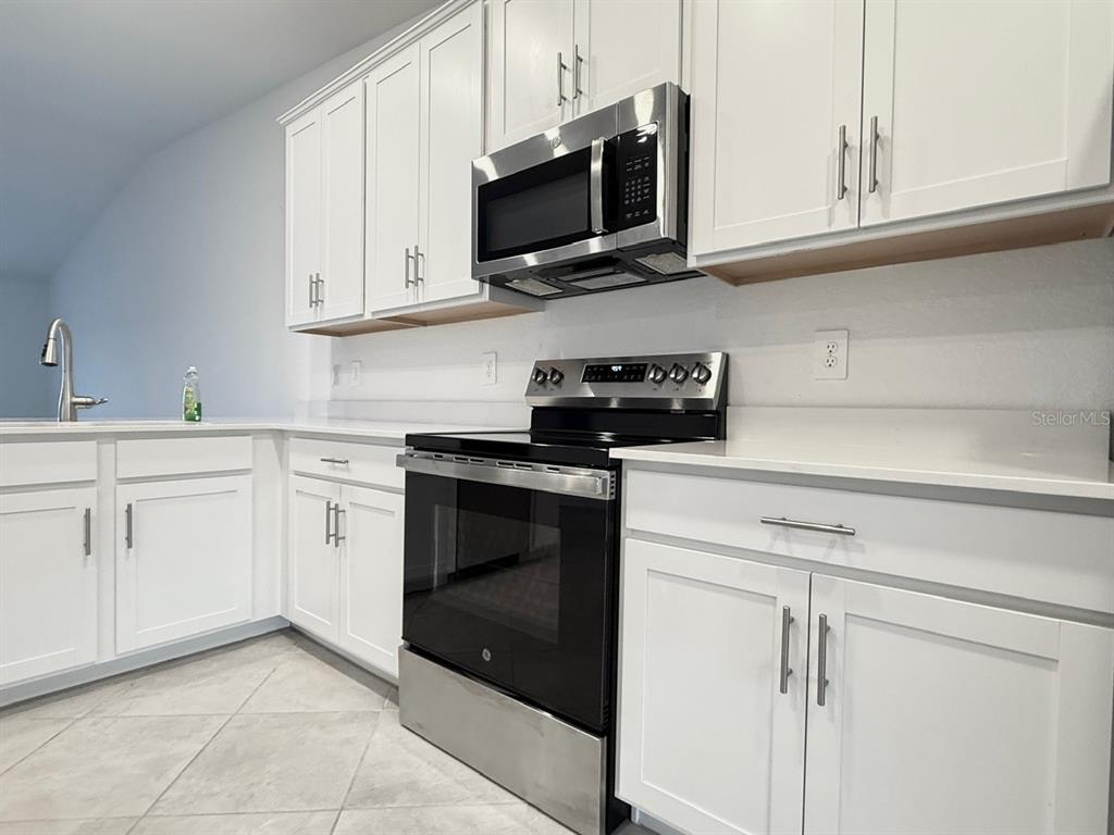 14261 Heritage Landing Boulevard, Unit 1621 Punta Gorda, FL 33955 - Photo 14 of 55 a kitchen with white cabinets stainless steel appliances and sink
