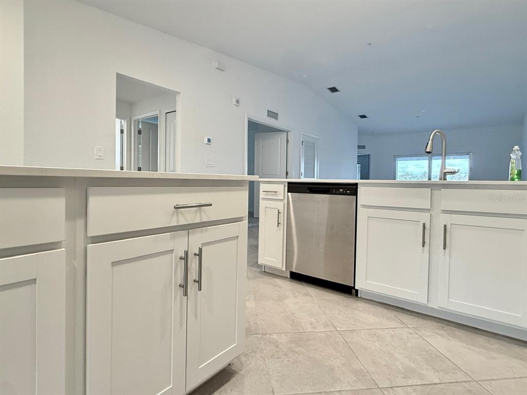 14261 Heritage Landing Boulevard, Unit 1621 Punta Gorda, FL 33955 - Photo 15 of 55 a kitchen with white cabinets and white appliances