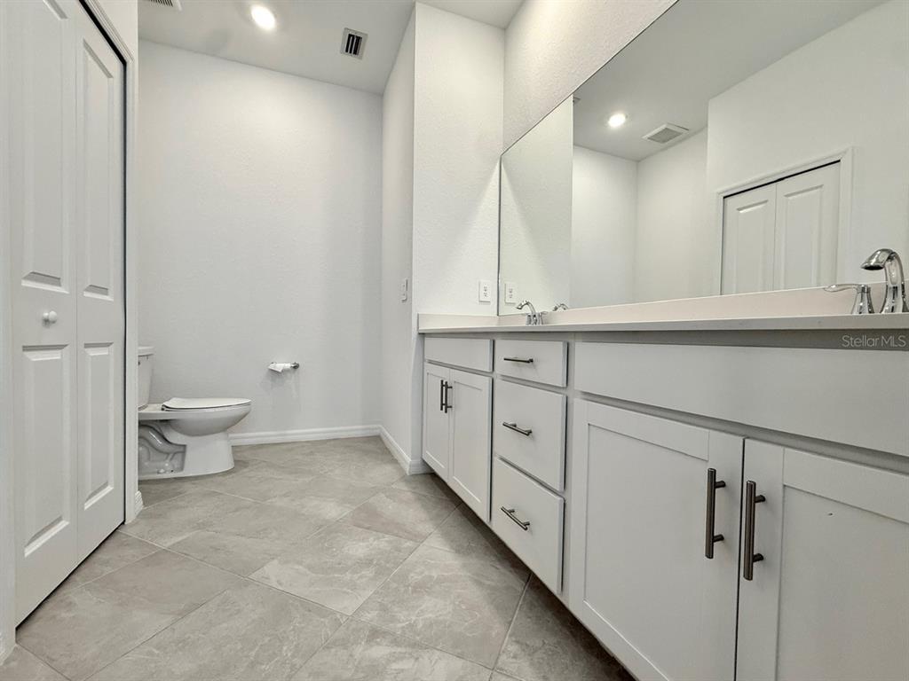14261 Heritage Landing Boulevard, Unit 1621 Punta Gorda, FL 33955 - Photo 26 of 55 a spacious bathroom with a double vanity sink toilet and a mirror
