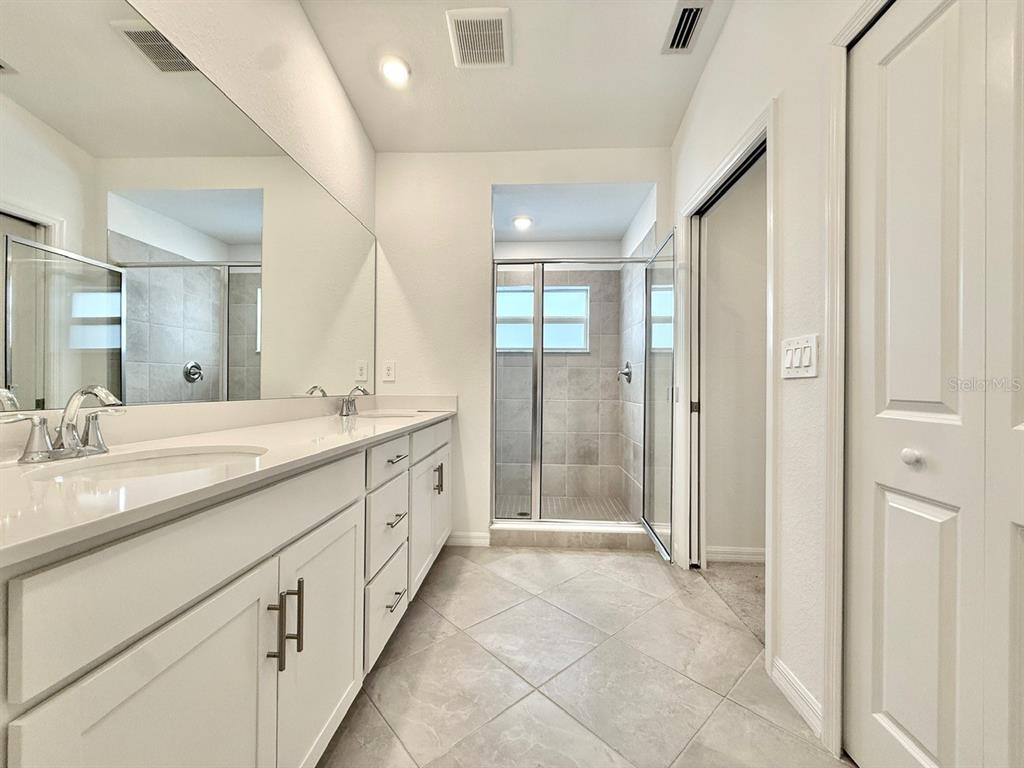 14261 Heritage Landing Boulevard, Unit 1621 Punta Gorda, FL 33955 - Photo 27 of 55 a spacious bathroom with a mirror a shower and vanity