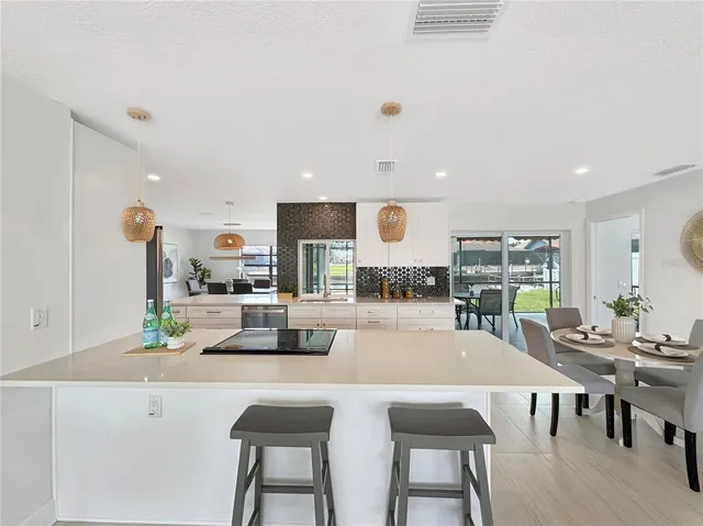 a dining room with kitchen island a table and chairs