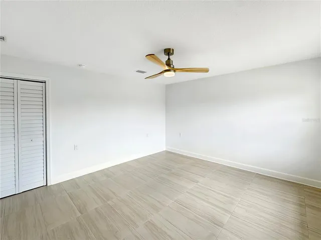 a view of a room with wooden floor and a ceiling fan