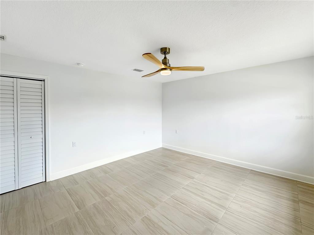 Undisclosed Address Port Richey, FL 34668 - Photo 36 of 44 a view of a room with wooden floor and a ceiling fan