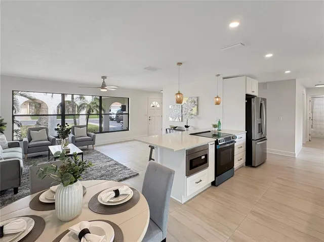 a kitchen with stainless steel appliances kitchen island granite countertop a sink and white cabinets