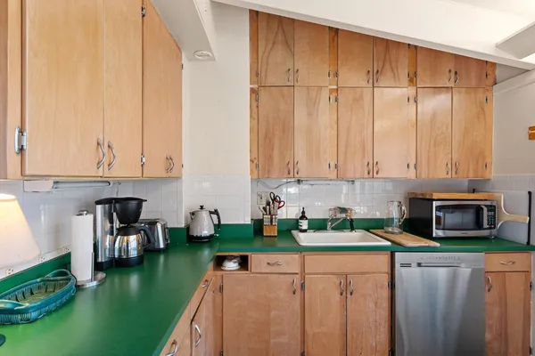 a kitchen with a stove a refrigerator and a stove top oven