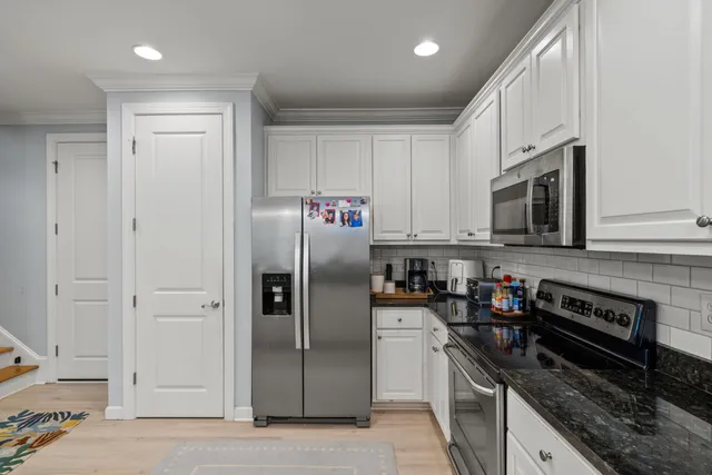 a kitchen with stainless steel appliances granite countertop a refrigerator and a stove top oven