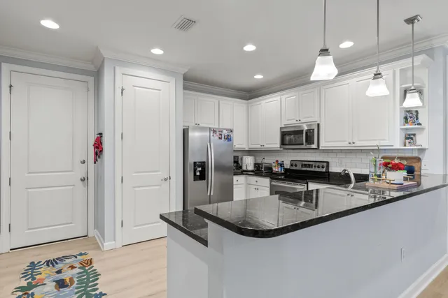 a kitchen with stainless steel appliances granite countertop a sink a stove a refrigerator and cabinets