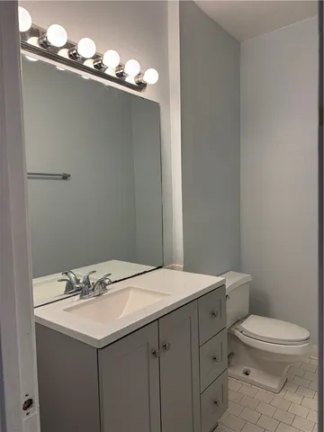 a bathroom with a sink a toilet and a mirror