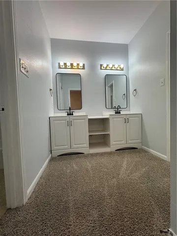 a bathroom with double vanity sinks and a mirror