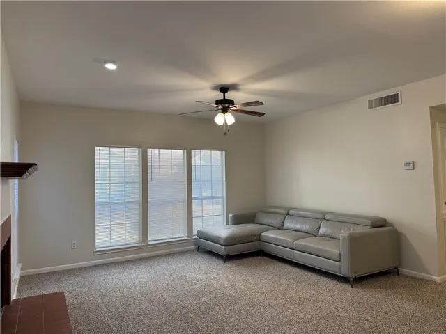 a living room with furniture and a ceiling fan