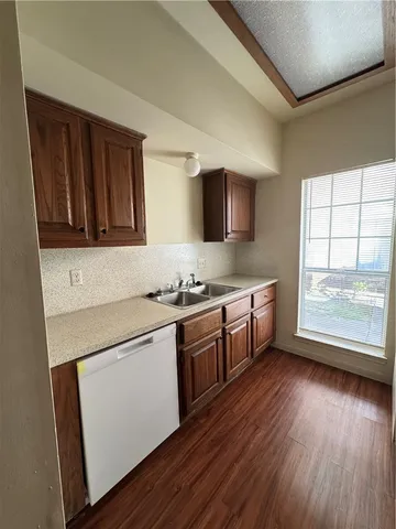 a kitchen with stainless steel appliances a sink cabinets and wooden floor