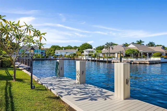a view of a lake with couches chairs in front of house