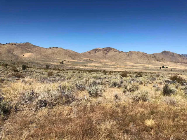 a view of a large mountain with mountains in the background