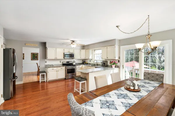 a kitchen with granite countertop cabinets stainless steel appliances and a dining table