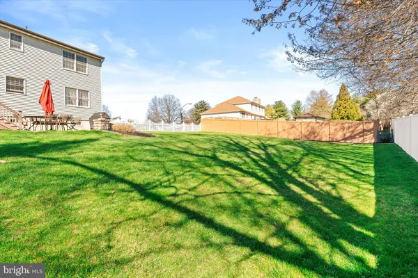 a view of a house with a big yard and large trees