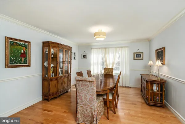 a kitchen with a stove a refrigerator a dining table and chairs with wooden floor