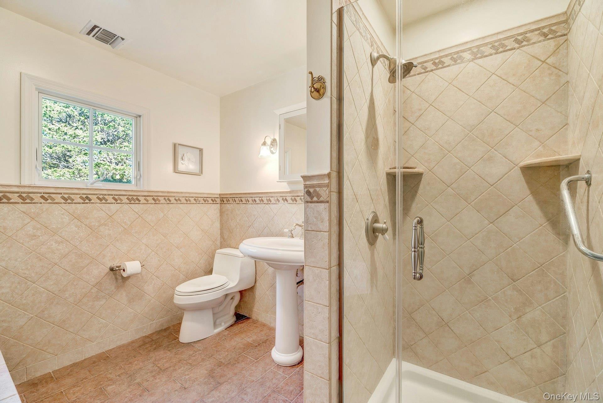 3600 Rocky Point Road East Marion, NY 11939 - Photo 27 of 45 Full bath with a shower stall, tile walls, a wainscoted wall, and tile patterned floors