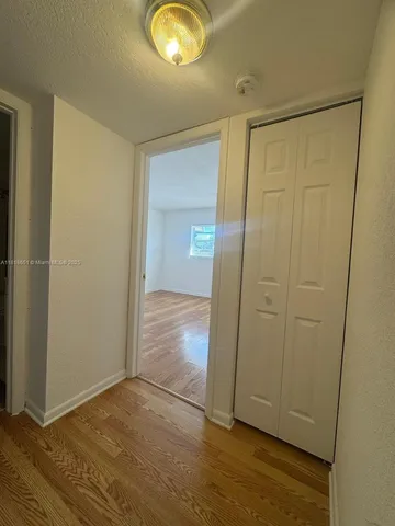 an empty room with wooden floor and closet