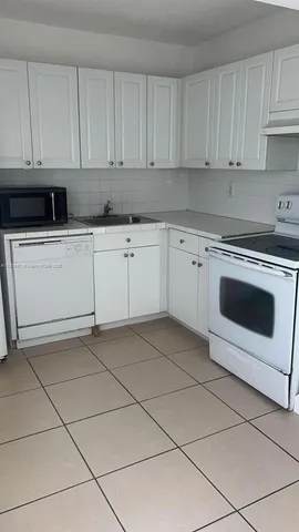 a kitchen with cabinets and white appliances