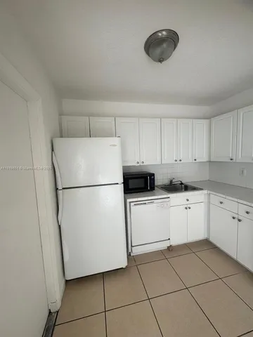 a kitchen with a refrigerator sink and cabinets