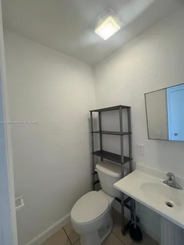 a bathroom with a toilet a sink and mirror
