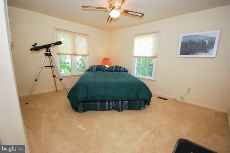 1503 Deer Point Way Reston, VA 20194 - Photo 14 of 21 a bedroom with a bed and a chandelier