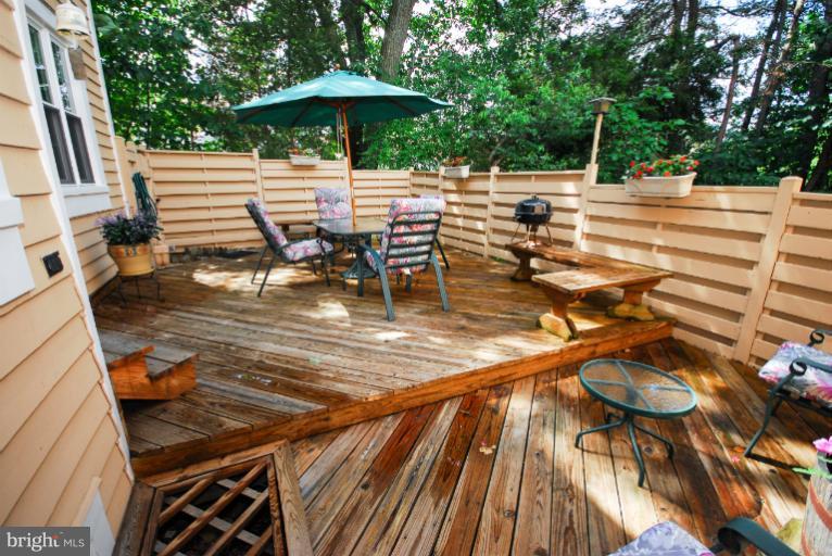 1503 Deer Point Way Reston, VA 20194 - Photo 6 of 21 a view of a patio with a table and chairs under an umbrella with wooden floor