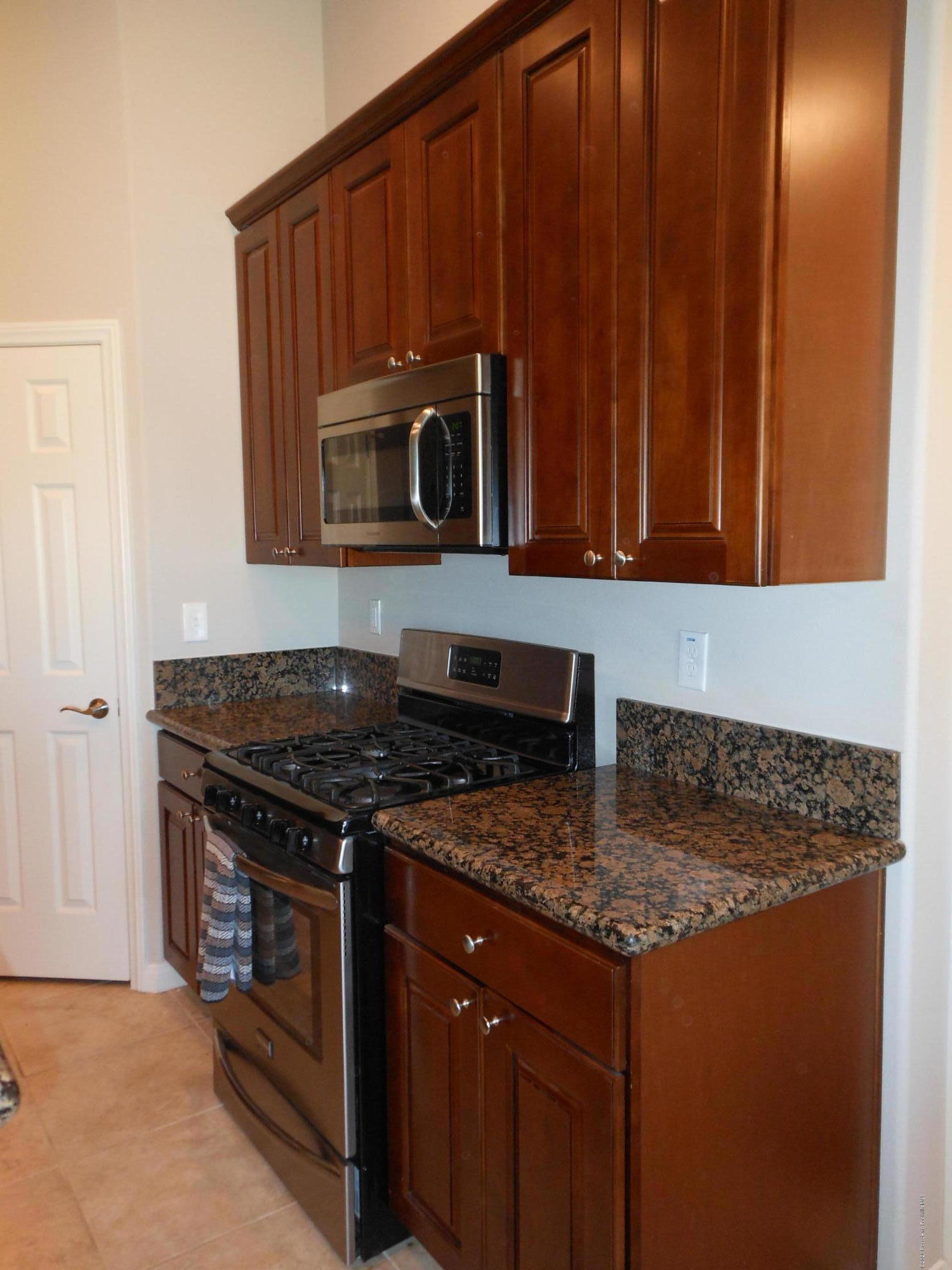 14806 Cheyenne Road Apple Valley, CA 92307 - Photo 4 of 15 a kitchen with granite countertop a stove top oven microwave and cabinets