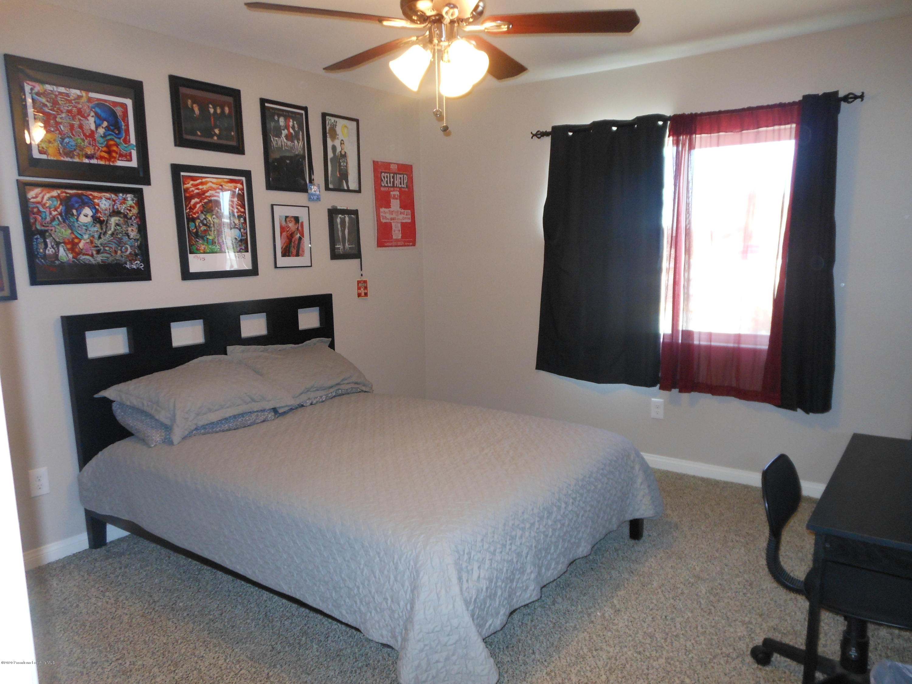 14806 Cheyenne Road Apple Valley, CA 92307 - Photo 8 of 15 a bedroom with a bed and a chandelier