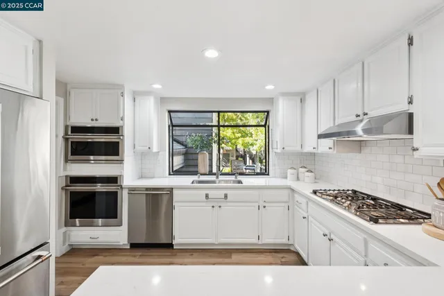 a kitchen with a sink stainless steel appliances and window