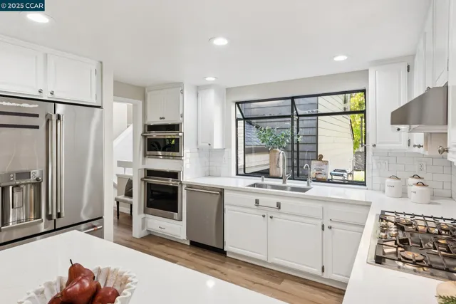 a kitchen with stainless steel appliances granite countertop a refrigerator and a sink
