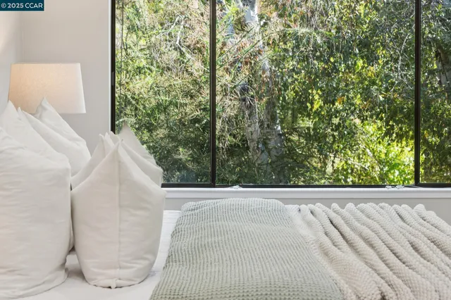 a spacious bedroom with a bed a couch and a chandelier