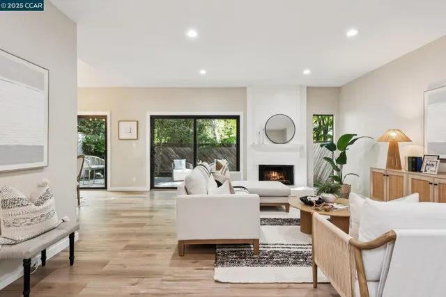 a living room with furniture large window and wooden floor