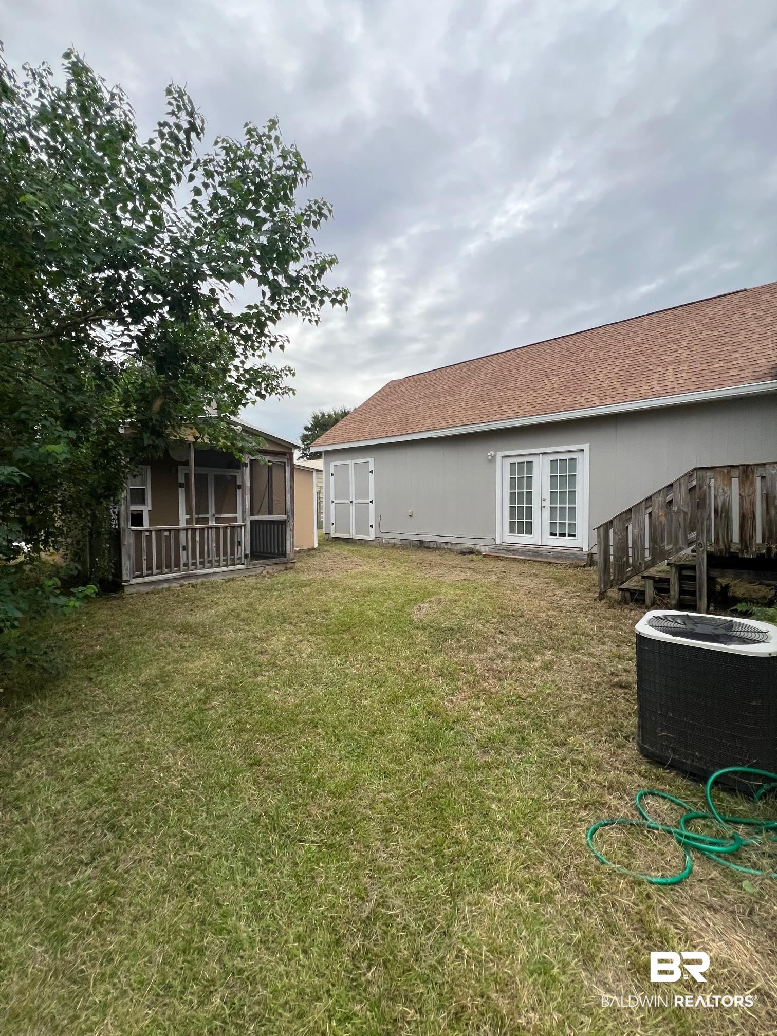 1985 Ridgewood Drive South Lillian, AL 36549 - Photo 20 of 40 View of yard featuring french doors and cooling unit