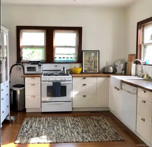 a kitchen with a stove a sink and a window