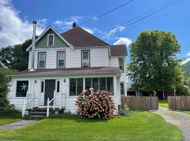a front view of house with a garden