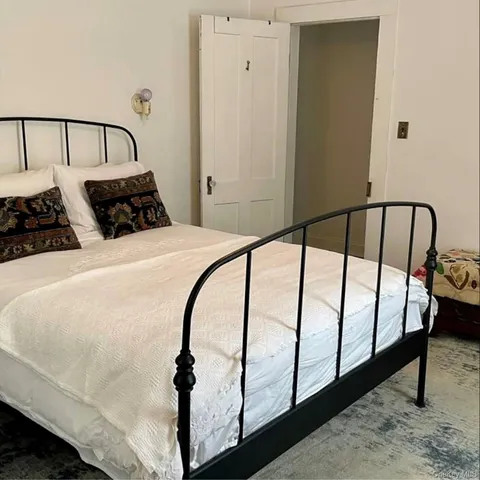 a bed sitting in a bedroom next to a window