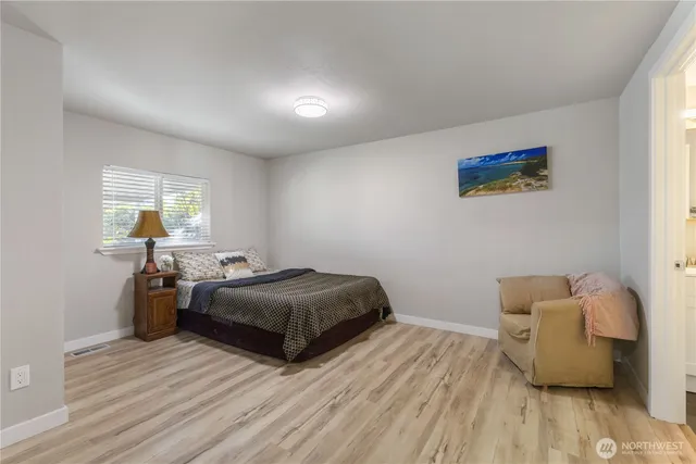 a bedroom with two beds and wooden floor