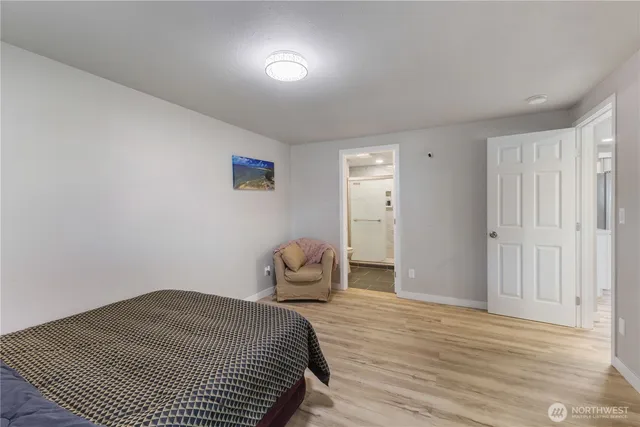a bedroom with a bed and wooden floor
