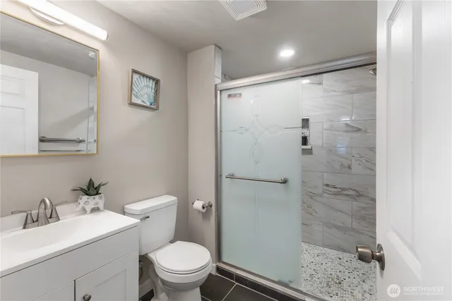 a bathroom with a granite countertop sink toilet and shower