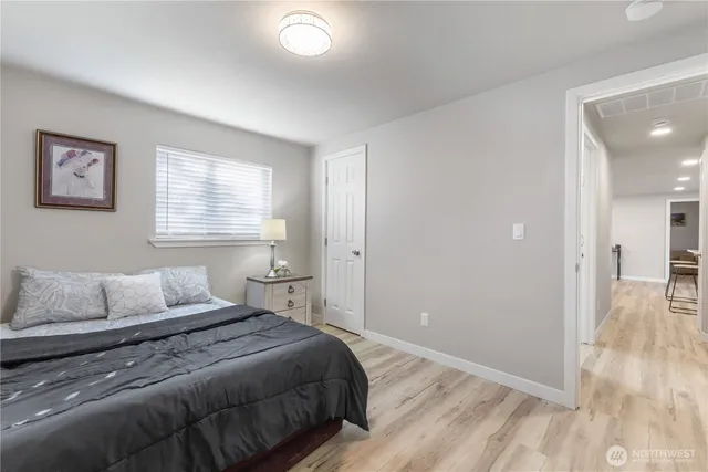 a bedroom with a bed and wooden floor