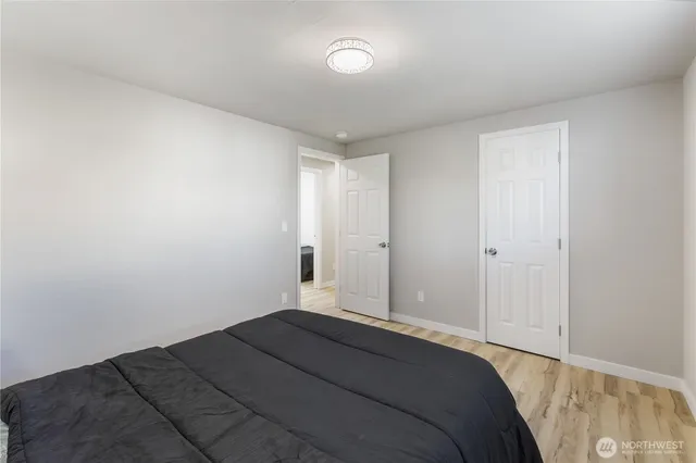 a bedroom with a bed and a lamp on the dresser