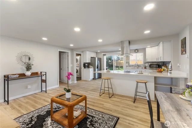 a living room with stainless steel appliances kitchen island granite countertop furniture and a kitchen view