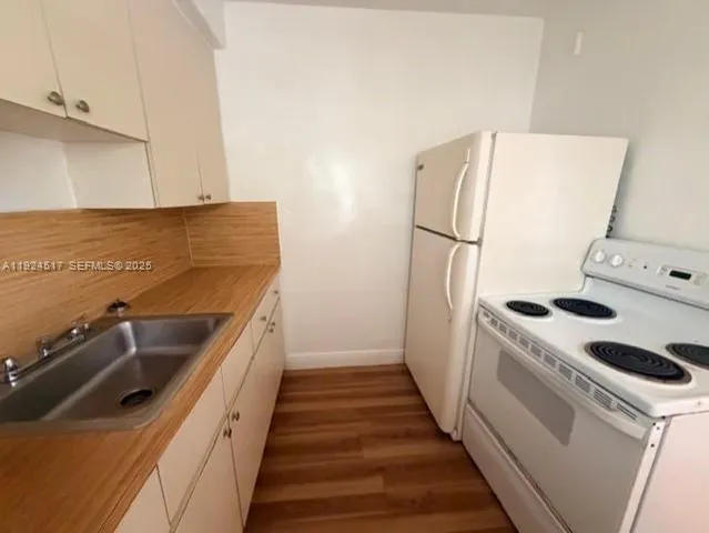 a kitchen with sink a refrigerator and washer