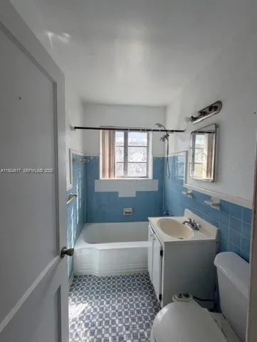a bathroom with a toilet a sink a mirror and bathtub