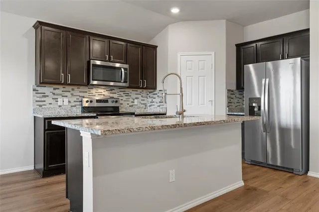 a kitchen with granite countertop stainless steel appliances and wooden cabinets