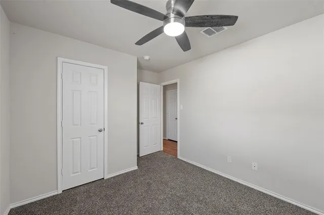 an empty room with a window and a fan