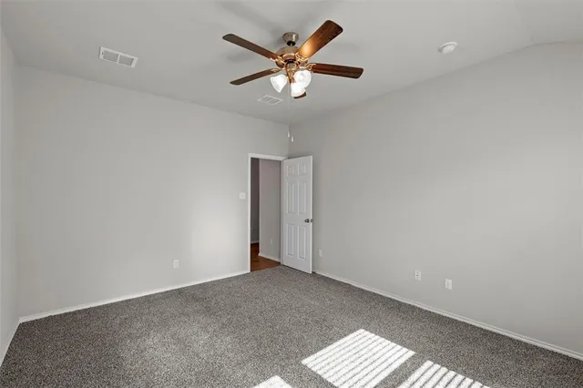 an empty room with a window and a ceiling fan